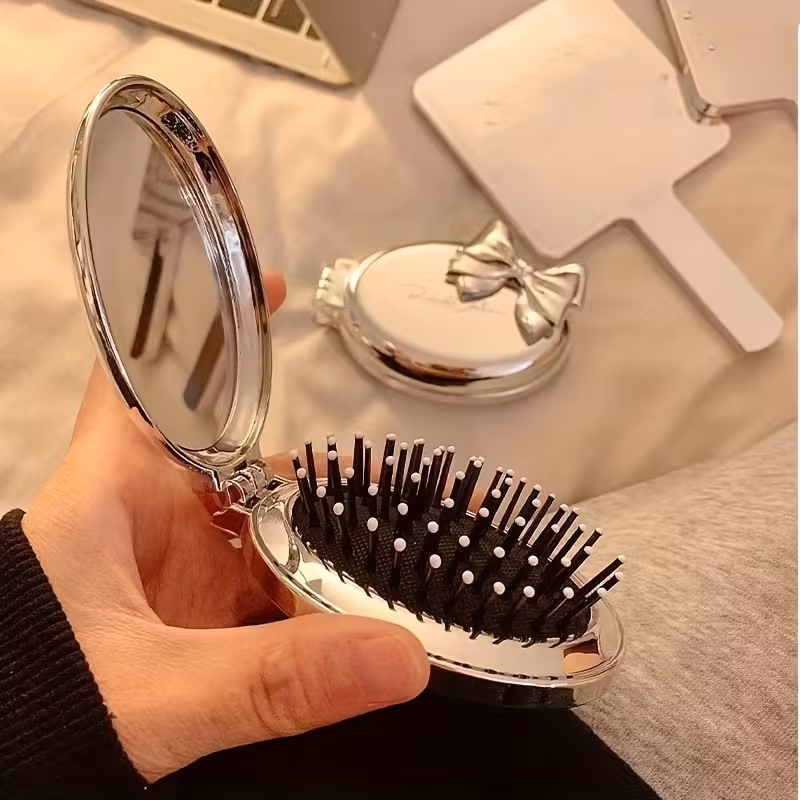 A Portable Folding Comb with a Bow Design, Featuring a Cushion for Gentle Hair Massage, And a Mini Mirror Integrated Into a Travel Comb for Women